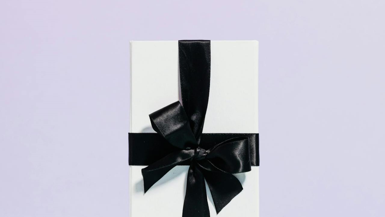 Stijlvol ingepakt cadeau met zwarte strik, perfect voorbeeld van geschenken die beweging stimuleren