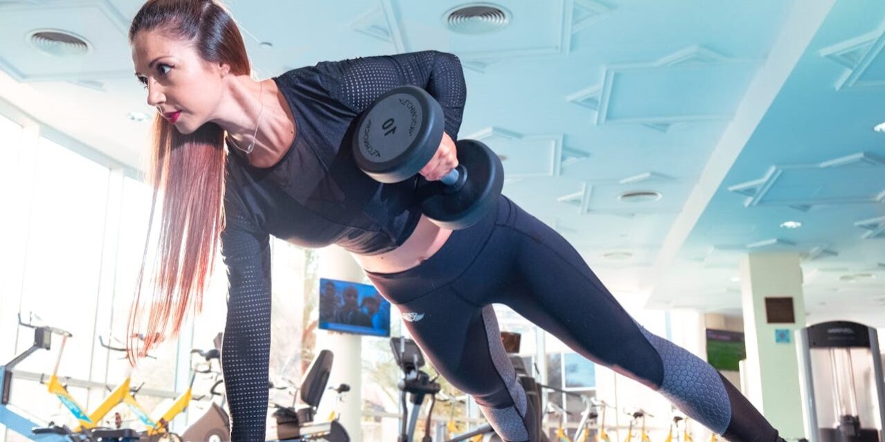 Vrouw voert een halteroefening uit in de sportschool als onderdeel van haar fitnessroutine