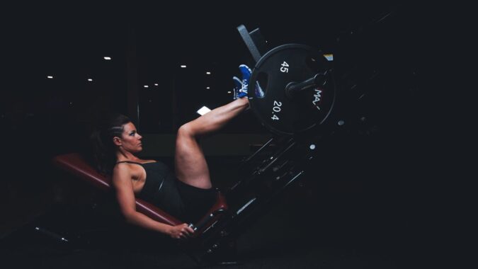 Vrouw voert leg press uit in de sportschool als onderdeel van haar trainingsroutine
