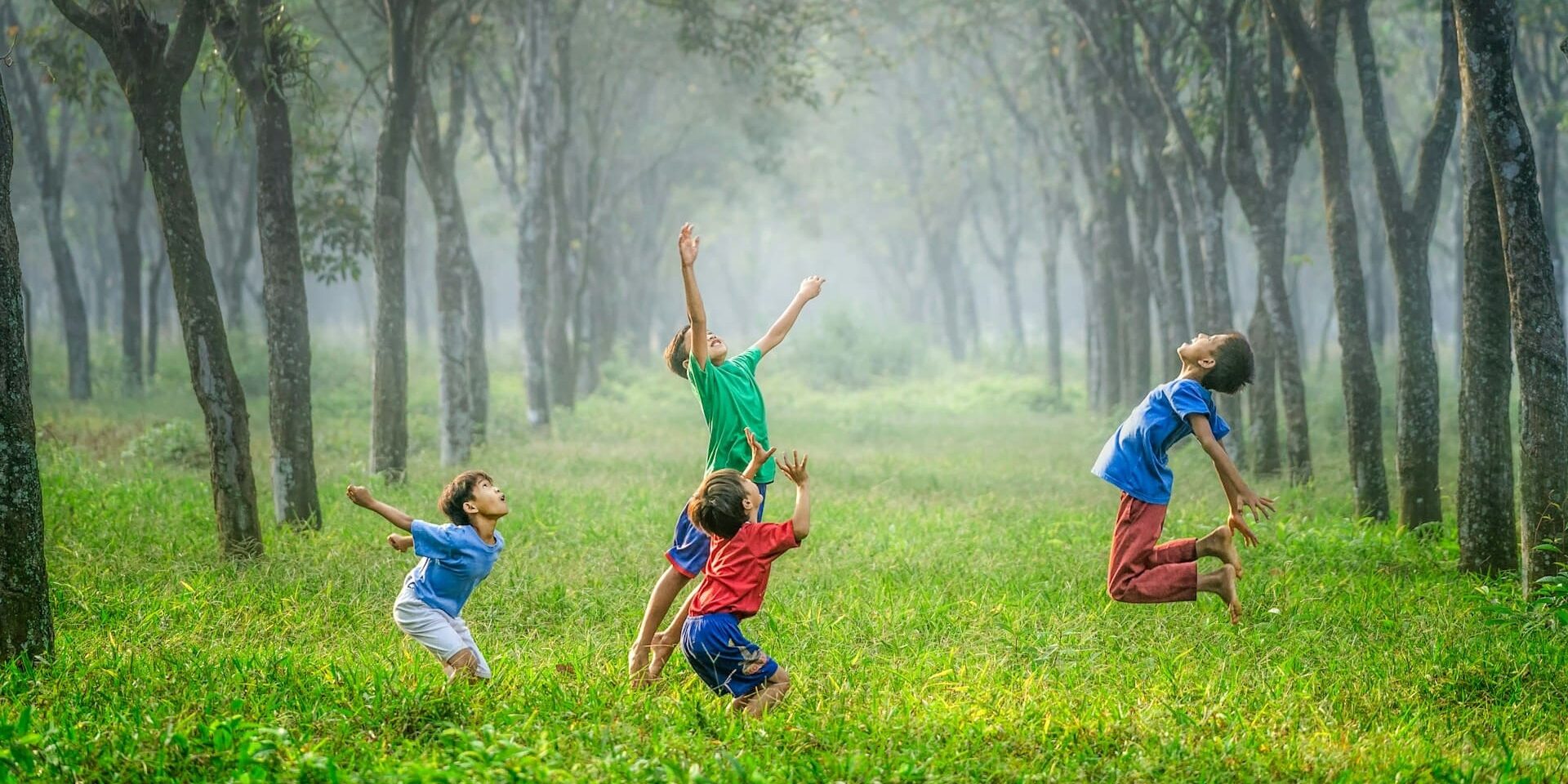 Kinderen rennen en springen in een bos, een moment van zelfredzaamheid en vrije beweging.